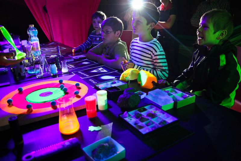 Kinder mit Kopflampen erkunden Fluoreszenz