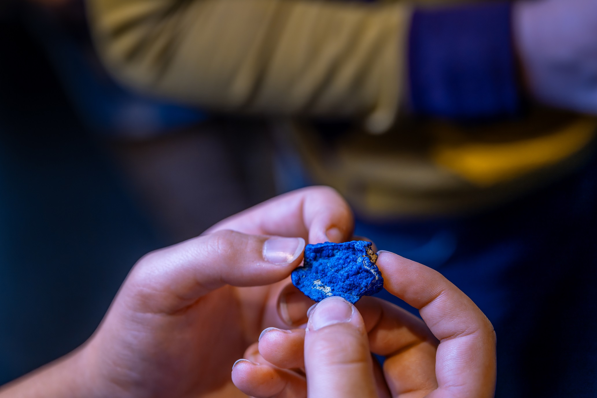 Zwei Hände ertasten ein Mineral.